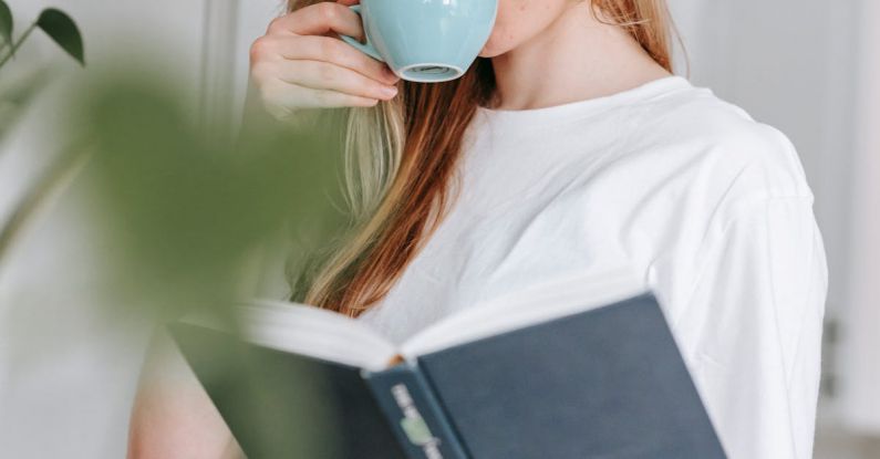 Smart Kitchen - Woman drinking coffee while reading book in kitchen